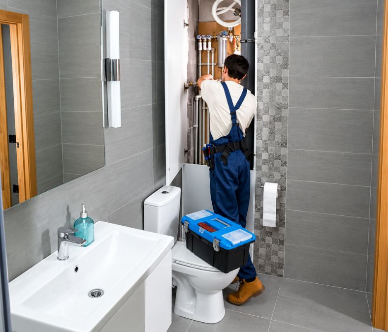 A technician repairs plumbing fixtures in a Davenport bathroom