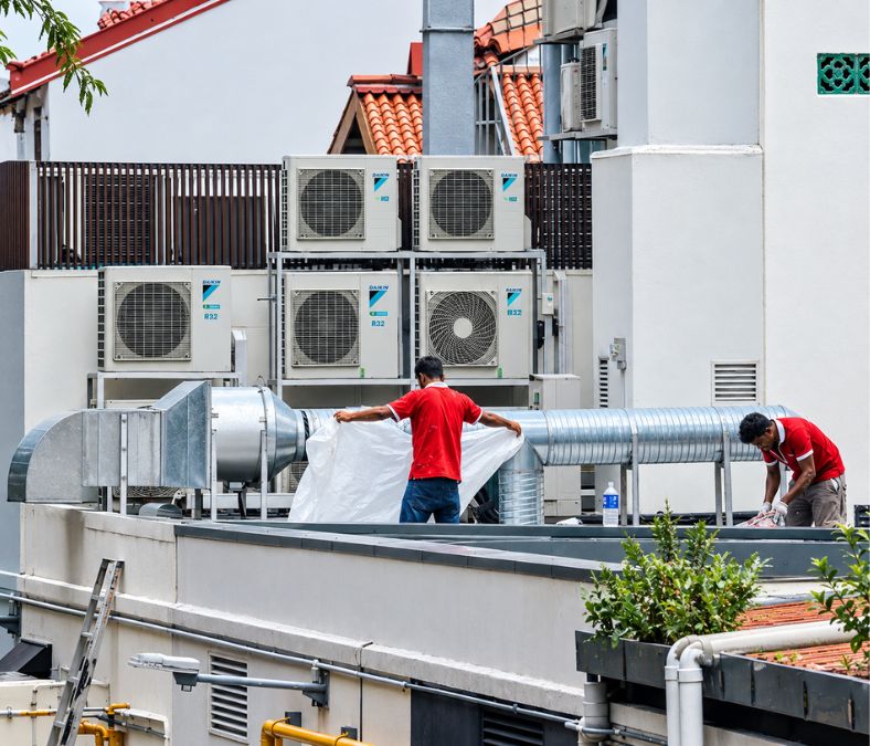 Technicians working around HVAC equipment during air conditioning service in Lakeland